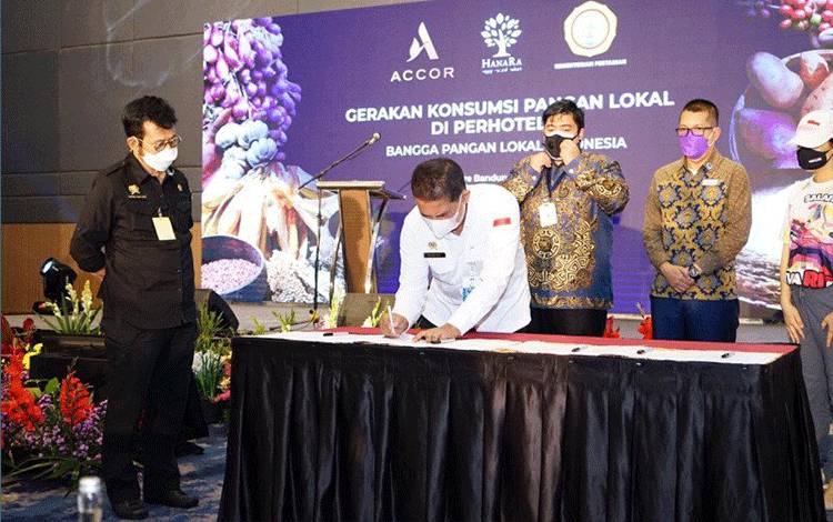 Menteri Pertanian Syahrul Yasin Limpo (kiri) menyaksikan penandatanganan nota kesepahaman antara petani dengan perhotelan dalam promosi dan pemanfaatan pangan lokal dari komoditas petani Indonesia. (HO/Kementerian Pertanian)
