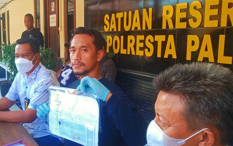 Kasatreskrim Polresta Palangka Raya Kompol Todoan Agung Gultom saat menunjukan barang bukti penipuan.