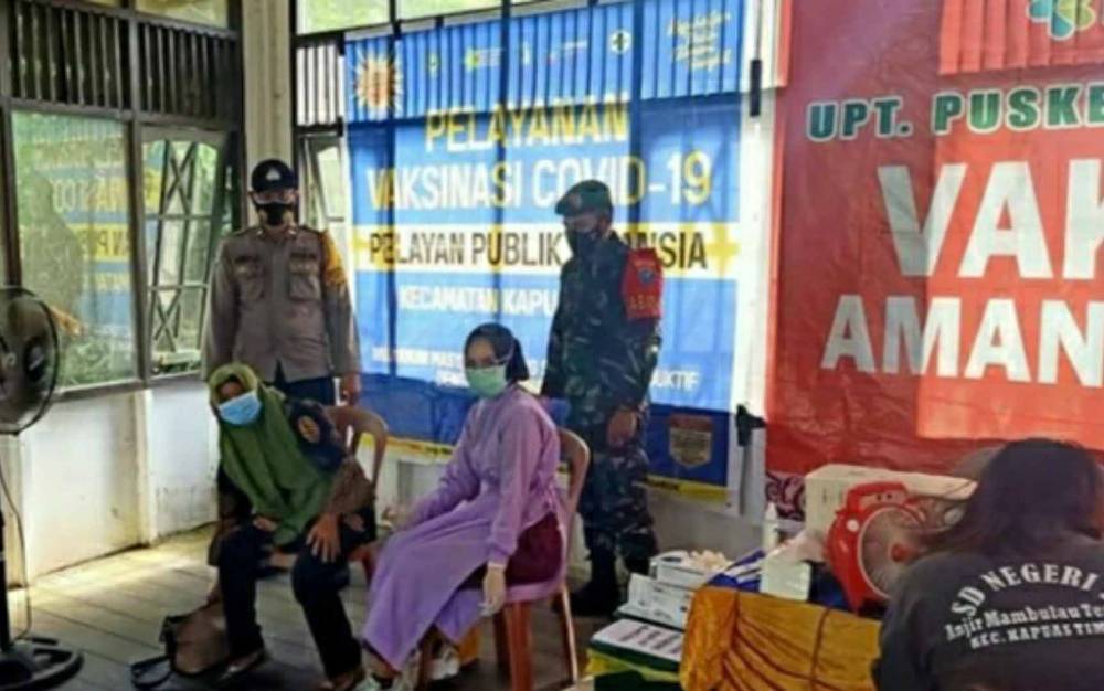 Babinsa Koramil Kapuas Timur saat mendampingi pelaksanaan vaksinasi covid-19 di puskesmas setempat, Selasa, 25 Mei 2021.