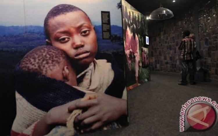 Pengunjung melihat foto-foto yang mendokumentasikan genosida 1994 di dalam Museum Memorial Genosida Kigali, Rwanda