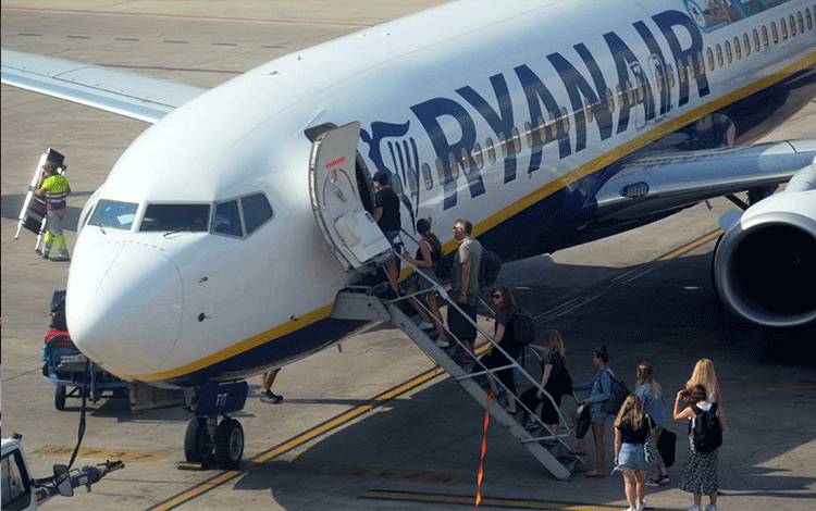 Penumpang menaiki pesawat Ryanair milik maskapai Irlandia. (REUTERS/Heino Kalis)