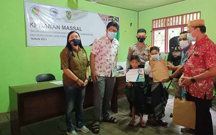 Pj Kades Persil Raya Robi Kuswanto didampingi pihak Rimba Raya Conservation, menyerahkan bingkisan dan sertifikat sunat kepada salah satu anak peserta sunatan  massal.