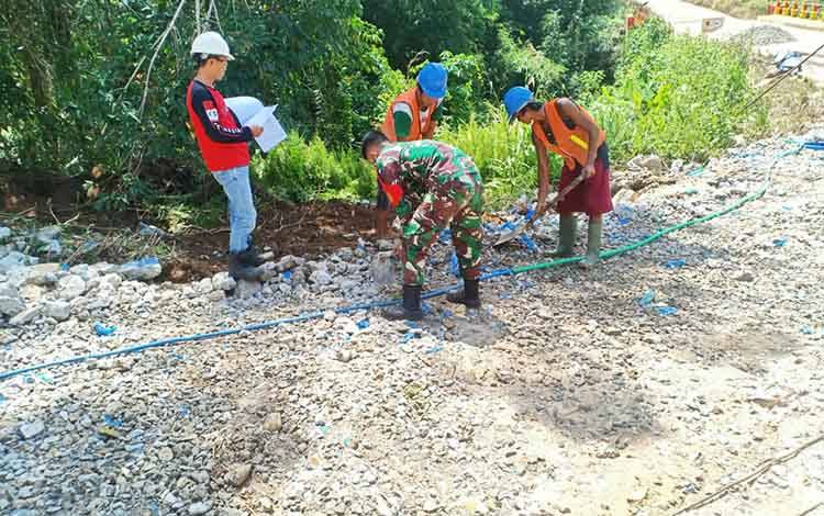 Babinsa Koramil 1013-01/Kandui Serda Rifki membantu warga memperbaiki saluran air yang rusak di Desa Kandui, Kecamatan Gunung Timang, Kabupaten Barito Utara, Senin, 7 Juni 2021.