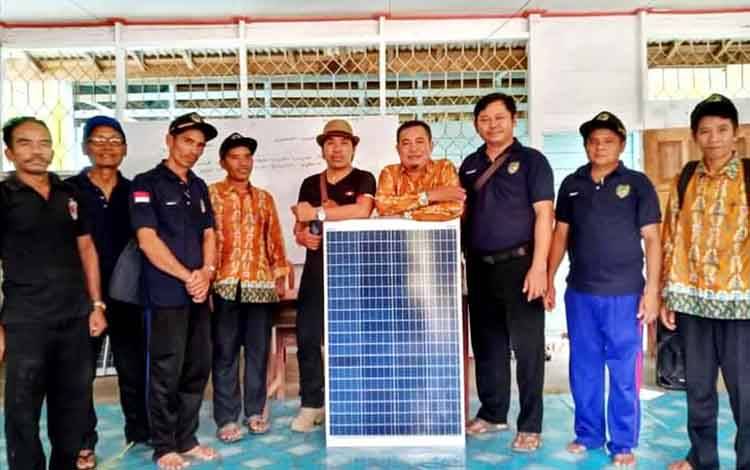  Pj Kepala Desa Sampirang I, Kecamatan Gunung Purei, Abdul Mutolip serahkan solar cell kepada warga setempat, di aula kantor desa, Selasa, 8 Juni 2021.