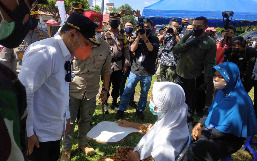 Gubernur Kalteng Sugianto Sabran berbincang bersama salah satu lansia saat menunggu giliran vaksin di SMPN 1 Kuala Pembuang