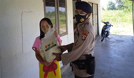 Personel Polsek Danau Sembuluh saat menyerahkan paket sembako kepada salah satu warga membutuhkan.