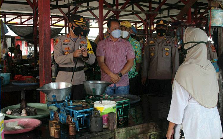 Kapolres Seruyan AKBP Bayu Wicaksono saat melakukan pengecekan stok dan harga pangan di pasar Kuala Pembuang.