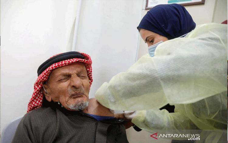 Seorang pria Palestina menerima vaksin AstraZeneca untuk melawan COVID-19 selama kampanye vaksinasi di Tubas, di Tepi Barat yang diduduki Israel, (25/3/2021). ANTARA FOTO/REUTERS / Raneen Sawafta/aww.