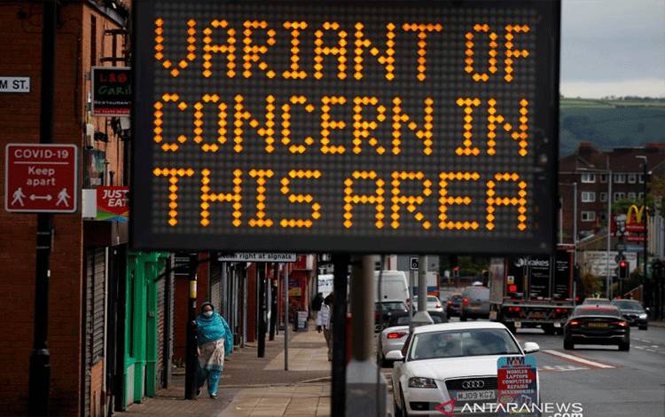 Seorang warga berjalan melewati tanda informasi di tengah wabah penyakit virus corona (COVID-19) di Bolton, Inggris, Senin (17/5/2021). REUTERS/Phil Noble/WSJ/sa.
