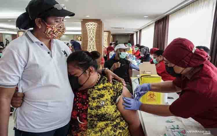 Reaksi seorang atlet Papua saat disuntik vaksin COVID-19 oleh petugas medis di Wisma Atlit Mandala Jayapura, Kota Jayapura, Papua, Sabtu (19/6/2021)