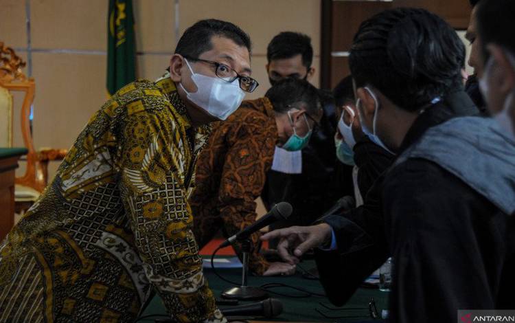 Terdakwa kasus korupsi kegiatan penjualan dan pemasaran pada PT Dirgantara Indonesia (PTDI) Tahun 2007-2017 Budi Santoso (kedua kiri) dan Irzal Rinaldi (kiri) berbincang dengan kuasa hukumnya saat menjalani sidang perdana di Pengadilan Tipikor, Bandung, Jawa Barat, Senin (2/11/2020)