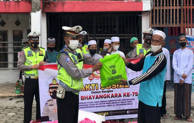 Personel Polres Kapuas saat menyerahkan bantuan paket sembako kepada penerima di Kuala Kapuas