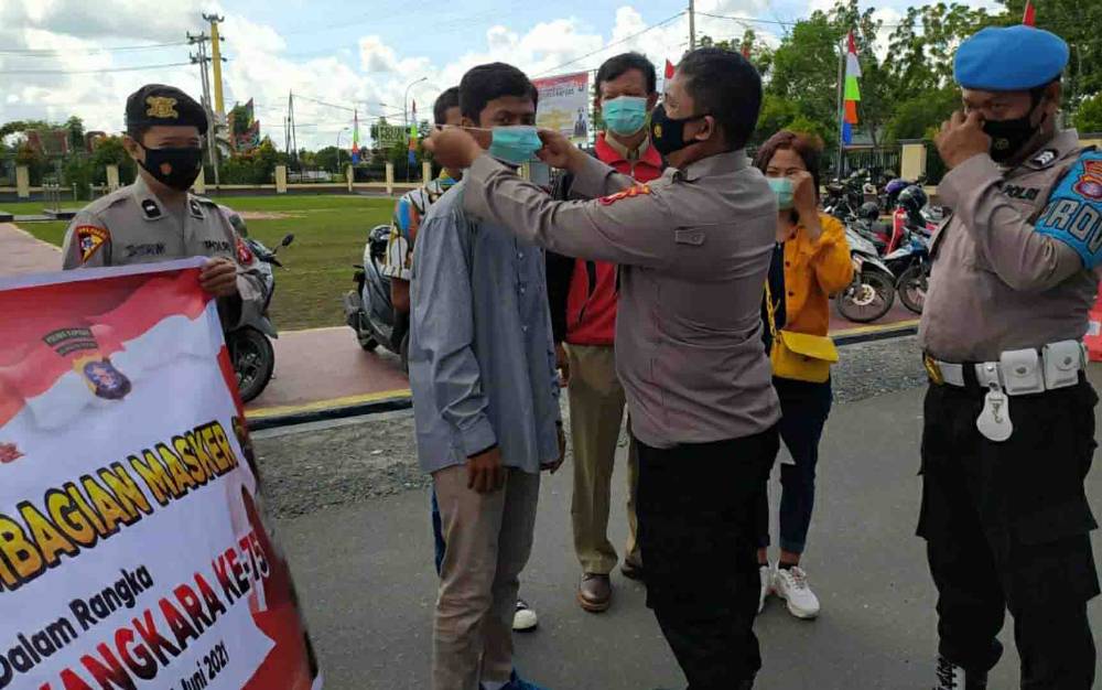 Personel Polres Kapuas saat membagikan masker kepada masyarakat pada Senin 28 Juni 2021.