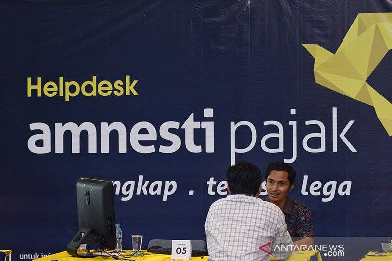 Petugas pajak melayani warga yang mengikuti program Pengampunan Pajak (Tax Amnesty) di Kantor Direktorat Jendral Pajak, Jakarta