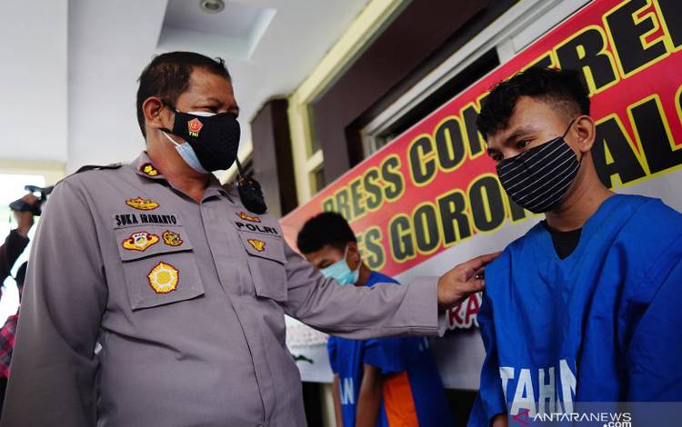 Kapolres Gorontalo Kota AKBP Suka Irawanto (kiri) bertanya kepada salah seorang tersangka pembacokan saat konferensi pers di Mapolres Gorontalo Kota, Kota Gorontalo, Gorontalo, Senin (28/6/2021)