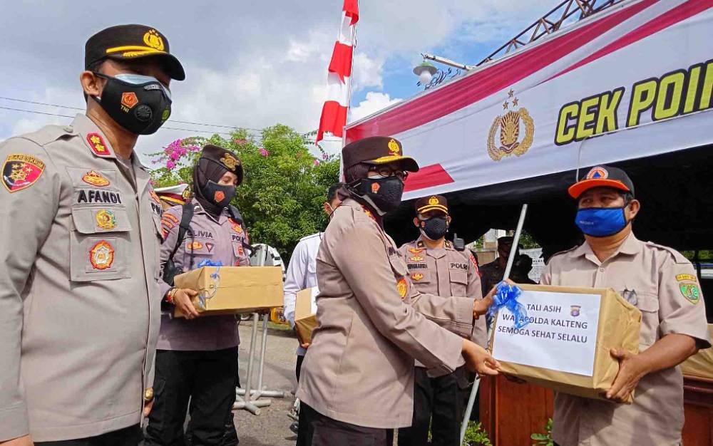 Wakapolda Kalimantan Tengah Brigjen Pol Ida Oetari Purnamasasi, memberikan bingkisan kepada petugas saat meninjau pos penyekatan perbatasan Pasar Panas Kabupaten Barito Timur.