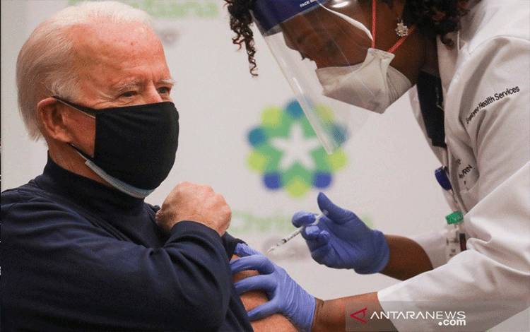 Praktisi perawat Tabe Mase memberi Presiden Amerika Serikat Joe Biden dosis vaksin penyakit virus corona (COVID-19) di ChristianaCare Christiana Hospital, di Newark, Delaware, Amerika Serikat, Senin (21/12/2020). ANTARA FOTO/REUTERS/Leah Millis/foc/cfo