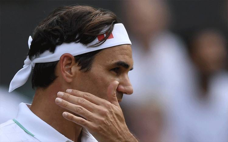 Petenis Swiss Roger Federer menyeka wajahnya di pertandingan perempat final turnamen Wimbledon melawan petenis Polandia Hubert Hurkacz di All England Lawn Tennis and Croquet Club, London, Inggris. (ANTARA/REUTERS/Toby Melville)