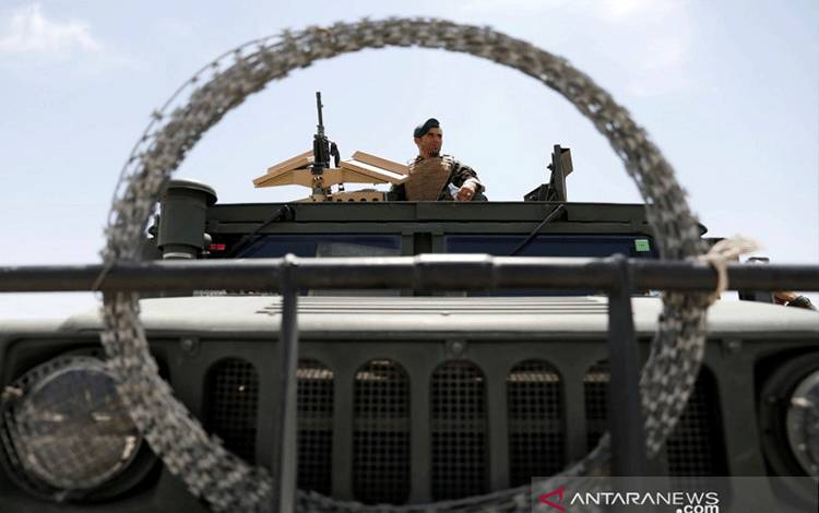 Aparat keamanan berjaga sambil duduk di kendaraan militer di pangkalan udara AS Bagram, setelah pasukan Amerika mengosongkannya, di provinsi Parwan, Afghanistan, Senin (5/7/2021). ANTARA FOTO/REUTERS/Mohammad Ismai/WSJ/djo