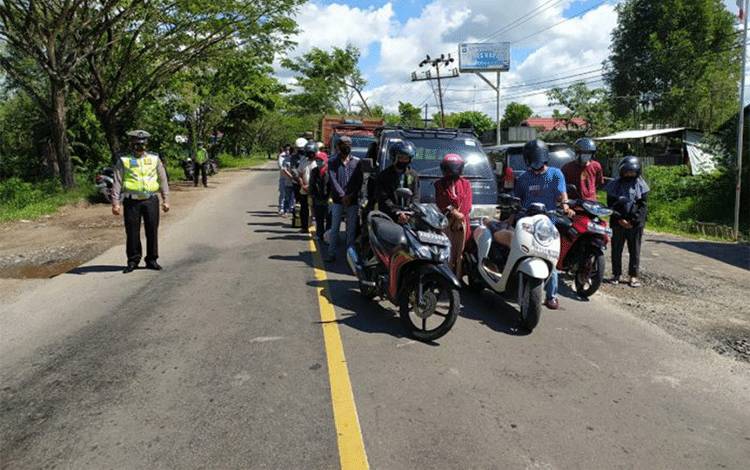 Personel Polres Kapuas dan pengendara mengheningkan cipta sejenak di Kota Kuala Kapuas pada Sabtu 10 Juli 2021.