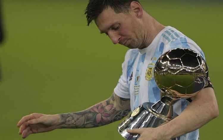Pemain Argentina Lionel Messi memegang trofi Pemain Terbaik Copa America setelah menjuarai Copa America 2021 usai mengalahkan Brazil dalam final di Stadion Maracana di Rio de Janeiro, Brazil, pada 10 Juli 2021. (Photo by CARL DE SOUZA / AFP)