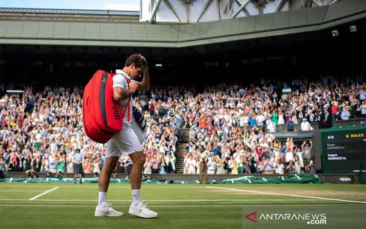 Petenis Swiss Roger Federer meninggalkan lapangan seusai dikalahkan petenis Polandia Hubert Hurkacz dalam perempat final turnamen Wimbledon di London, Inggris, Rabu (7/7/2021). (ANTARA/REUTERS/POOL/Edward Whitaker)