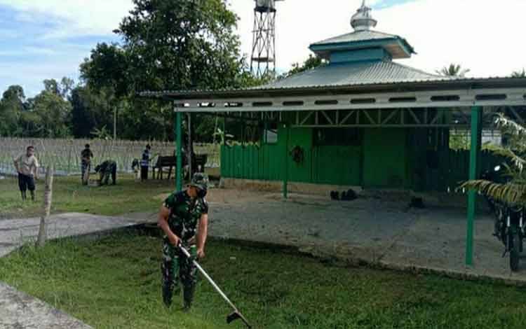 Anggota Kodim 1011 Kuala Kapuas melakukan karya bakti dengan membersihkan lingkungan Masjid Nurul Huda.
