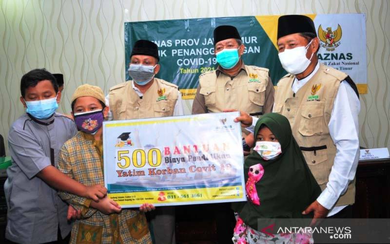 Pengurus BAZNAS Jatim saat memberikan beasiswa secara simbolis kepada anak dari orang tua yang meninggal dunia akibat COVID-19 di Surabaya, Jumat (17/7/2021). (foto : ANTARA/Fiqih Arfani)