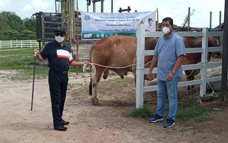 H Abdul Rasyid AS menyerahkan bantuan sapi kurban bagi masyarakat yang secara simbolis diterima Chief Operating Officer (COO) PT Sawit Sumbermas Sarana (SSMS), Tbk Nasaruddin bin Nasir di Sulung Ranch, Sabtu, 17 Juli 2021