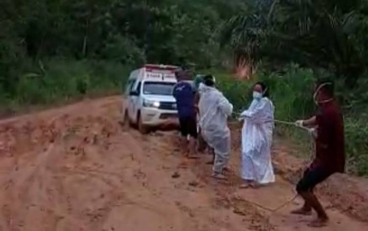 Nakes berpakaian hazmat yang menarik ambulan saat terjebak lumpur di Desa Sambi Kecamatan Aruta