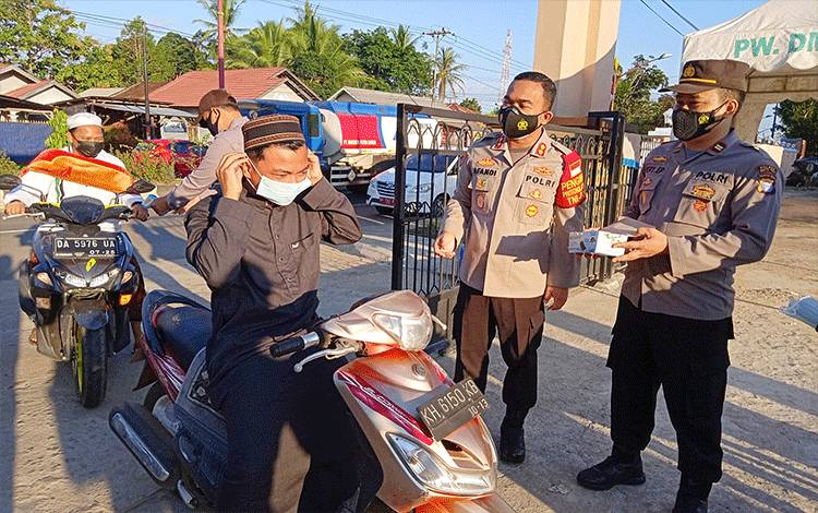 Kapolres Barito Timur, AKBP Afandi Eka Putra memberikan masker baru kepada jemaah yang akan melaksanakan salat Idul Adha di Masjid Agung Ar-Rahman Tamiang Layang.
