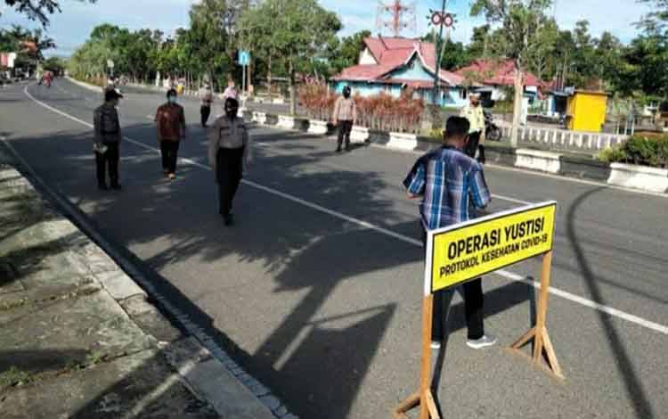 Personel Polsek Selat saat menggelar Operasi Yustisi di Jalan Tambun Bungai pada Jumat, 23 Juli 2021.