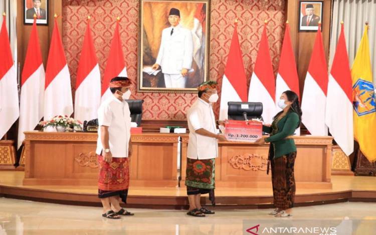Gubernur Bali Wayan Koster saat secara simbolis menyerahkan Bantuan Produktif Usaha Mikro (BPUM) kepada perwakilan penerima di Denpasar, Kamis (8/7/2021)