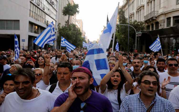 Para pengunjuk rasa meneriakkan berbagai slogan saat berdemonstrasi untuk menentang vaksinasi penyakit virus corona (COVID-19) di Athena, Yunani, Sabtu (24/7/2021)