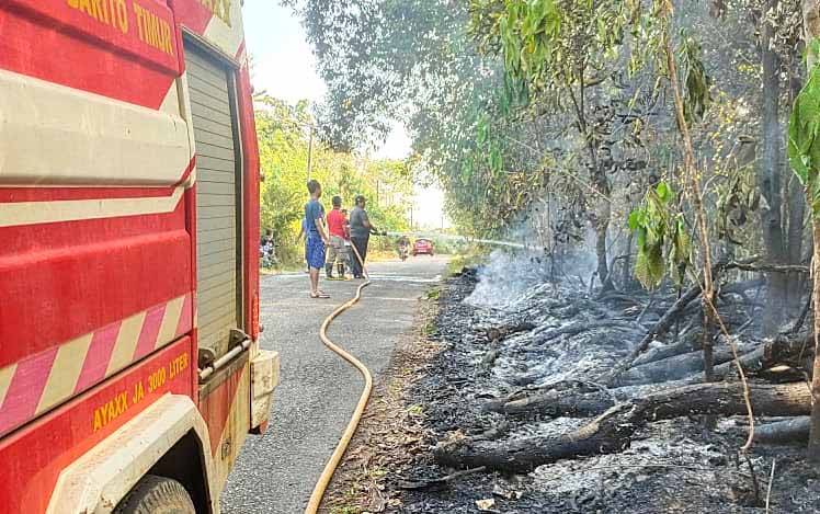 Petugas pemadam kebakaran mendinginkan lahan yang terbakar di RT 03, Desa Dorong, Kecamatan Dusun Timur, Minggu, 25 Juli 2021.