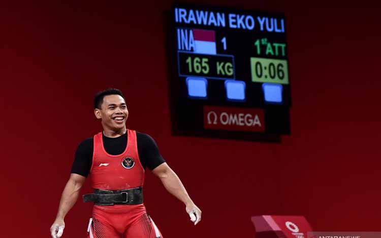 Lifter Indonesia Eko Yuli Irawan tersenyum seusai melakukan angkatan clean and jerk dalam kelas 61 kg Putra Grup A Olimpiade Tokyo 2020 di Tokyo International Forum, Tokyo, Jepang, Minggu (25/7/2021)