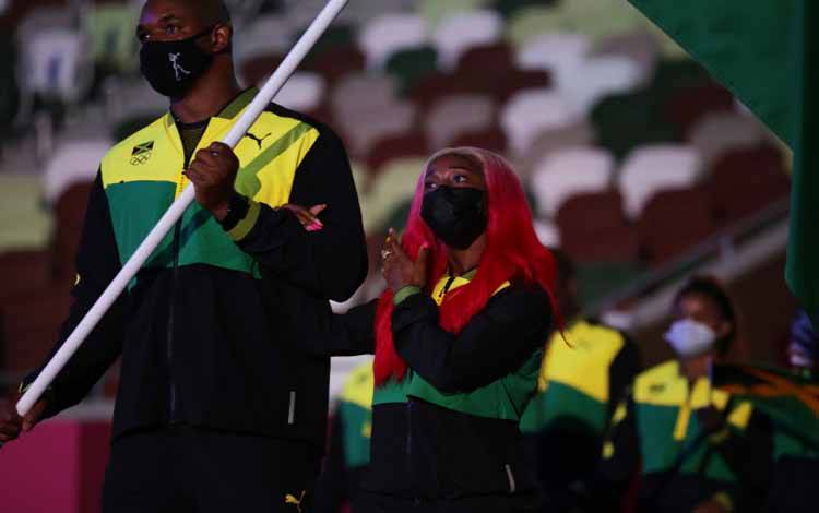 Dua atlet pembawa bendera kontingen Jamaika Ricardo Brown dan Shelly-Ann Fraser-Pryce (kanan) saat defile atlet dalam upacara pembukaan Olimpide Tokyo 2020. Shelly-Ann Fraser-Pryce akan menjadi sorotan atletik yang memulai lomba Jumat ini