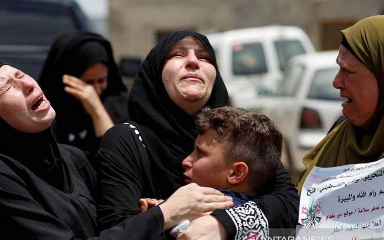 Kerabat dan ibunda warga Palestina Mohammed Al-Tamimi, yang menurut keterangan pihak berwenang tewas oleh pasukan Israel dalam bentrokan hari Jumat kemarin, menangis saat pemakaman almarhum di Deir Nidham, wilayah pendudukan Israel, Tepi Barat, Sabtu (24/7/2021)