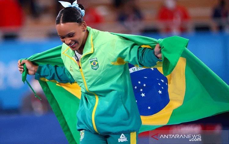 Pesenam Brazil Rebeca Andrade melakukan selebrasi dengan bendera negaranya seusai memenangi medali emas Olimpiade Tokyo 2020 untuk nomor senam indah artistik alat kuda lompat perorangan putri di Ariake Gymnastics Centre, Tokyo, Jepang, Minggu (1/8/2021). (ANTARA/REUTERS/Lindsey Wasson)
