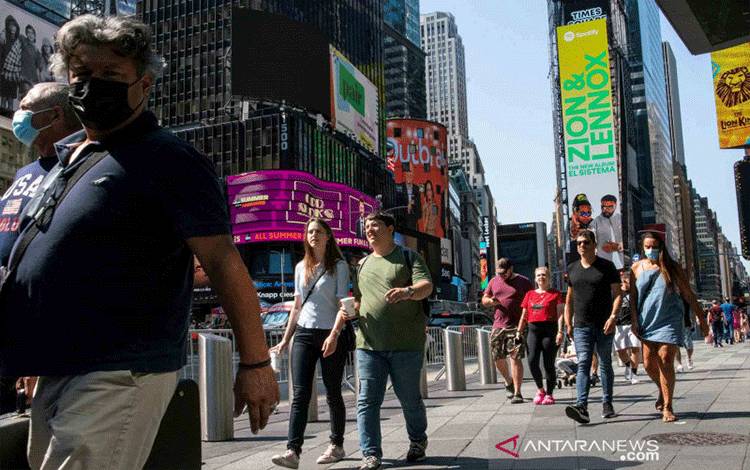 Sejumlah orang dengan masker di wajahnya berjalan di kawasan Times Square, Kota New York seiring dengan semakin meningkatnya penularan COVID-19 akibat virus SARS-CoV-2 varian Delta di New York, Amerika Serikat, Jumat (23/7/2021). Varian Delta dari virus COVID-19 menjadi penyebab lebih dari 80 persen kasus baru yang terjadi di Amerika Serikat. ANTARA FOTO/REUTERS/Eduardo Munoz/wsj.