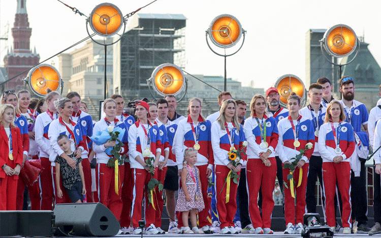 Atlet-atlet Rusia disumbat upacara penyambutan yang megang sekembalinya dari Olimpiade Tokyo 2020 yang berlangsung di Lapangan Merah di Moskow, Rusia, 9 Agustus 2021. (REUTERS/EVGENIA NOVOZHENINA)