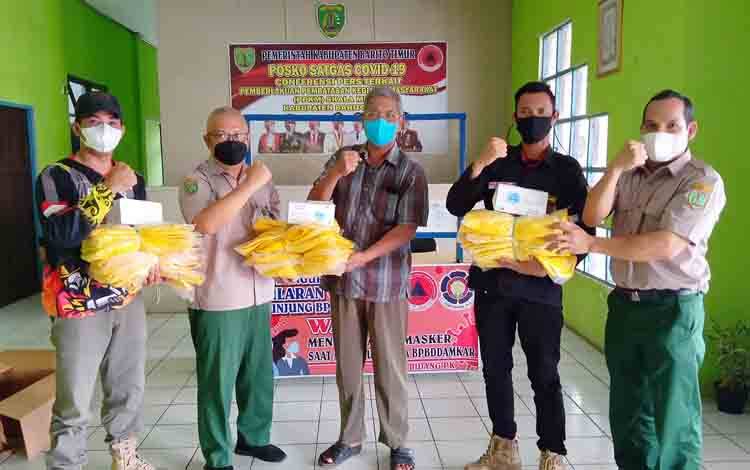 BPBD Damkar Barito Timur menyerahkan bantuan baju dan masker bagi relawan BPK swasta.