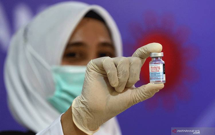 Petugas medis Rumah Sakit Umum Zainal Abidin (RSUZA) memperlihatkan vaksin Moderna untuk tenaga kesehatan di Banda Aceh, Aceh, Senin (9/8/2021). ANTARA FOTO/Irwansyah Putra/rwa. (ANTARA FOTO/IRWANSYAH PUTRA)