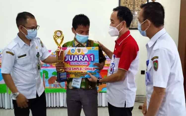 Muhammad Fahrizal saat menerima hadiah dan penghargaan dari Plt Dinas Pendidikan Kalimantan Tengah, Ahmad Syaifudi.