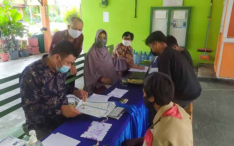 Pelajar melaksanakan cap tiga jari ke sekolah di SMP Negeri 2 Sampit, dengan berupaya menerapkan protokol kesehatan.
