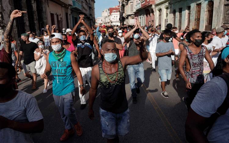 Warga berseru mengecam pemerintah dalam aksi protes menentang maupun mendukung pemerintah, di tengah wabah penyakit virus corona (COVID-19), di Havana, Kuba, Minggu (11/7/2021). ANTARA FOTO/REUTERS/Alexandre Meneghini/HP/djo