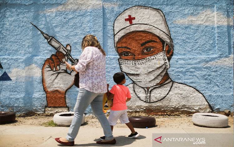 Warga berjalan melewati sebuah mural di tengah penyebaran penyakit virus korona (COVID-19) di Rio de Janeiro, Brazil, Jumat (12/3/2021). ANTARA FOTO/REUTERS/Pilar Olivares/foc/cfo