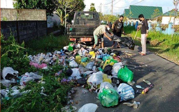 Petugas saat membersihkan sampah yang berserakan di jalan Sisingamangaraja III.
