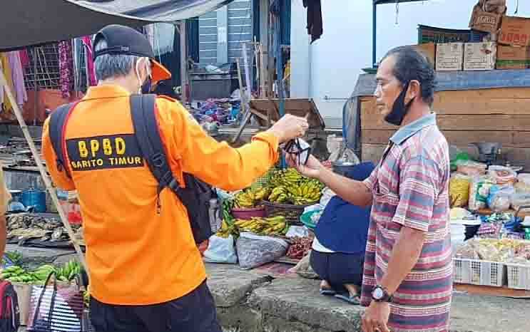 Petugas BPBD Damkar membagikan masker kepada pengunjung Pasar Tamiang Layang.