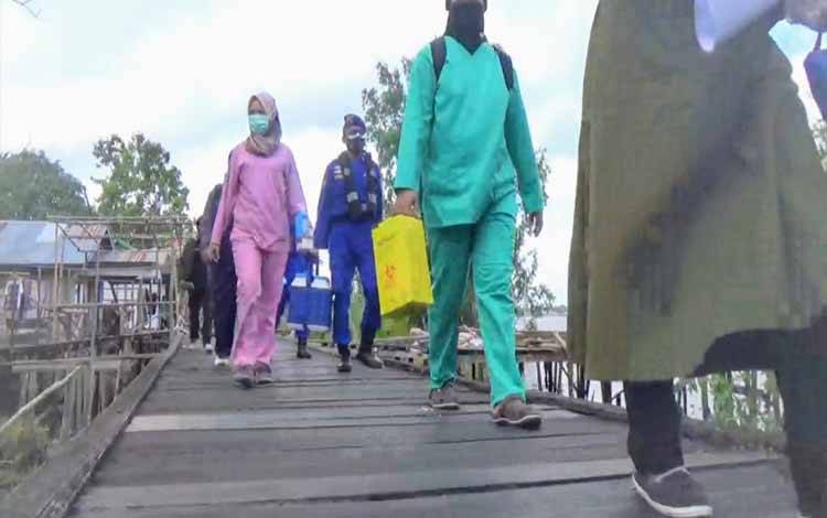 Petugas Ditpolairud Polda Kalteng bersama tenaga kesehatan mendatangi rumah warga di bantaran Sungai Mentaya, untuk jemput bola vaksinasi Covid-19